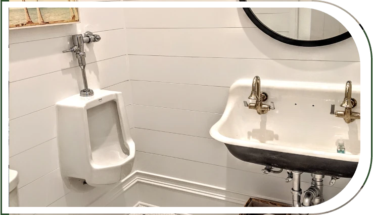 A bathroom with two urinals and a mirror.