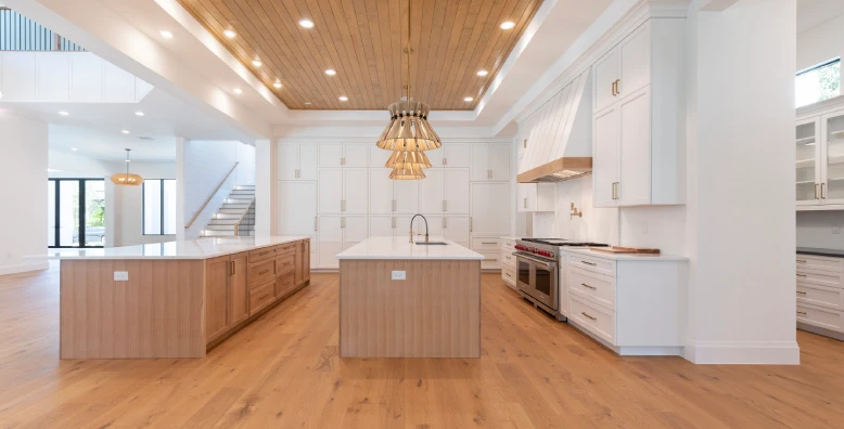 A large kitchen with white cabinets and wood floors.