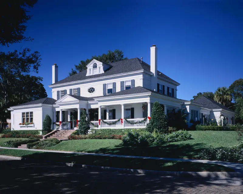 A large white house with a lawn in front of it.