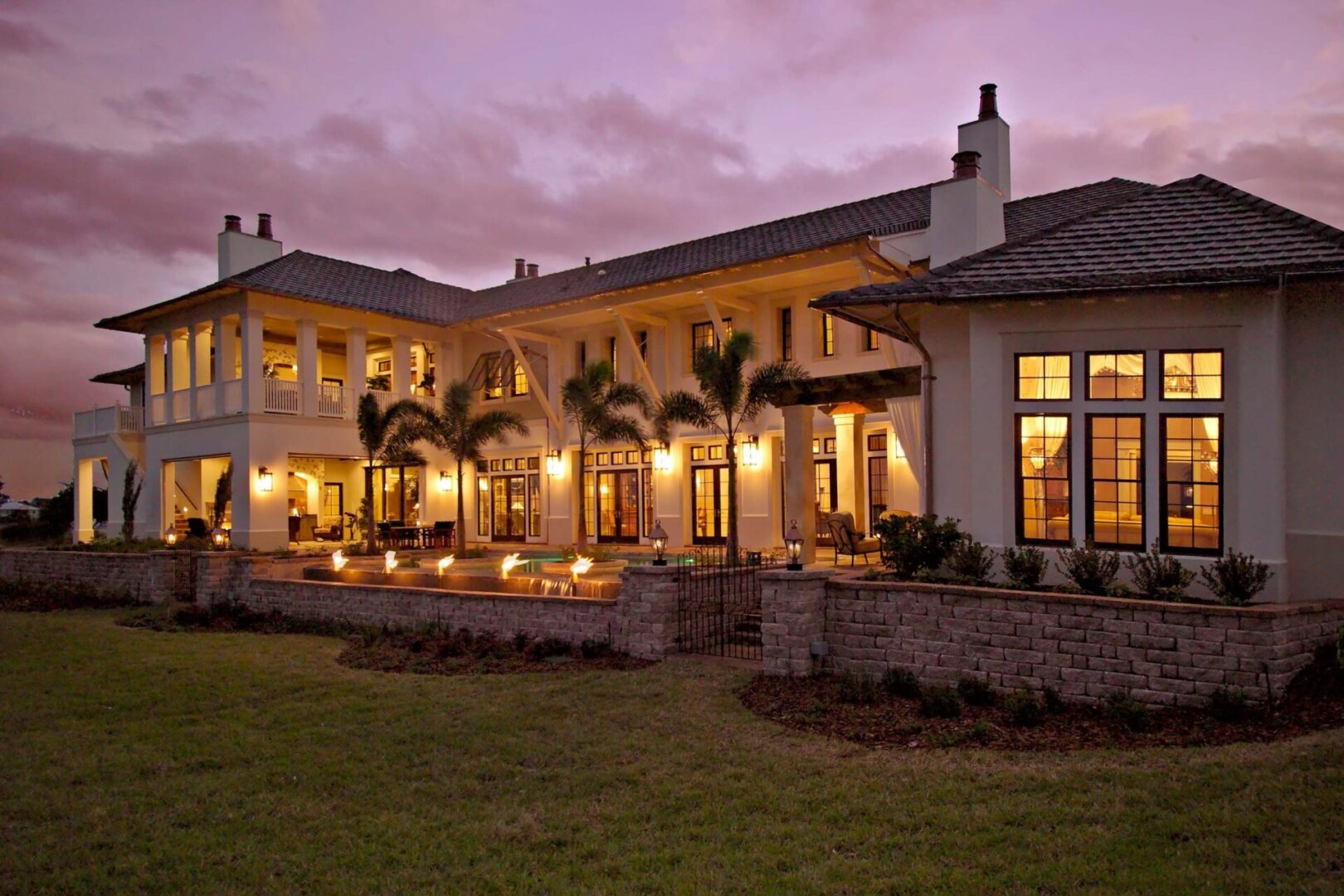 A large white house with palm trees in the yard.